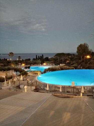 - une grande piscine d'eau bleue la nuit dans l'établissement Cap Esterel studio H3, à Agay