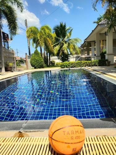 a basketball sitting on a bench next to a swimming pool at The Phura Villa Khaolak - SHA Extra Plus in Khao Lak