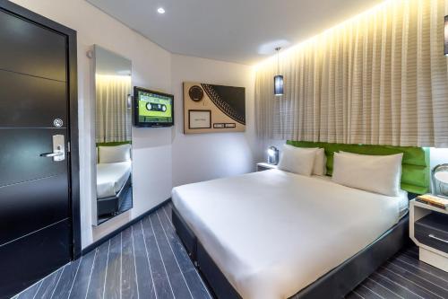 una camera con un grande letto e una televisione di 130 Rock Apartments a Tel Aviv