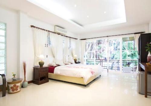 - une chambre avec un lit et une grande fenêtre dans l'établissement Banyan House Samui bed and breakfast (Adult Only), à Chaweng