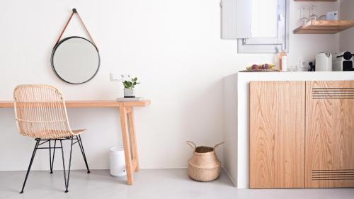 a kitchen with a table and a mirror and a chair at Pénde Suites in Livadion