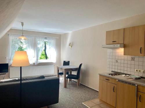 eine Küche mit einem Tisch und einem Sofa in einem Zimmer in der Unterkunft Apartment Hillmer in Niederhaverbeck