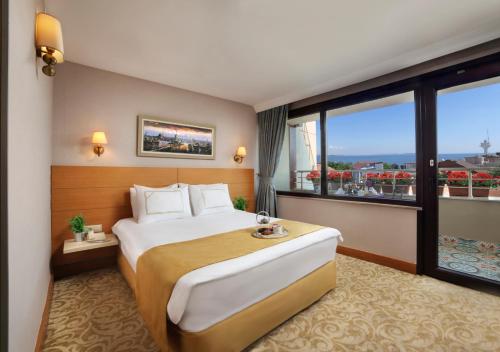 a hotel room with a large bed and a large window at Almina Hotel - Special Class in Istanbul