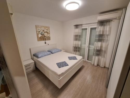 a small bedroom with a bed and a window at Apartment Markus in Makarska