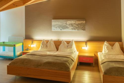 a hotel room with two beds and two lamps at Hotel Auwirt Zentrum in Saalbach-Hinterglemm