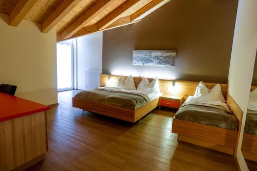 a bedroom with a bed and a window at Hotel Auwirt Zentrum in Saalbach-Hinterglemm