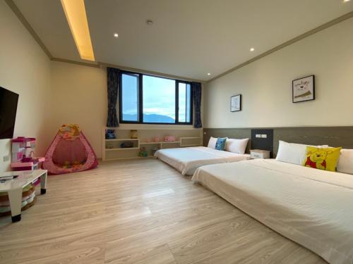 1 Schlafzimmer mit 2 Betten und einer Kinderschaukel in der Unterkunft 育薦關山民宿 臺東縣民宿1585號 in Guanshan
