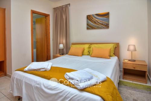 1 dormitorio con 1 cama con 2 toallas en Apollon Harmony Villa, by Coral Sun Villas, en Bahía de Coral