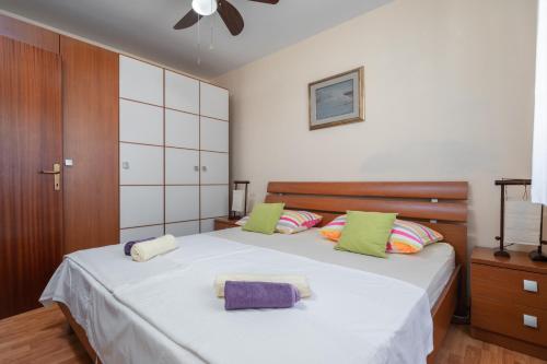 una camera da letto con un grande letto con cuscini verdi e viola di kuća za odmor Tino a Vela Luka (Vallegrande)