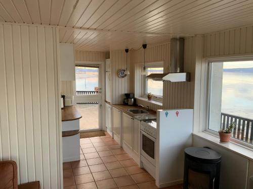 a kitchen with a white refrigerator and a balcony at Loff Holiday Houses in Aabenraa