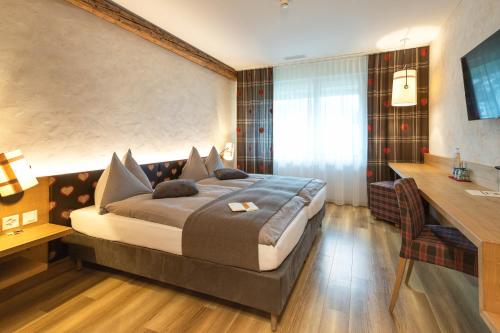 a hotel room with a bed and a desk and a desk at Landgasthof Kreuz - Der Zwischenstopp mit Herz auf dem Weg in den Süden in Kappel bei Olten