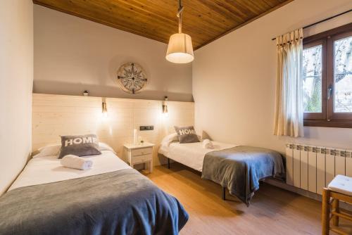 een slaapkamer met twee bedden en een raam bij Apartaments Alta Muntanya in Barruera