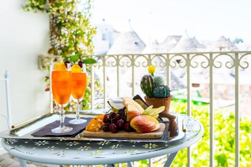 a table with a tray of fruit and drinks on a balcony at Palazzo Scotto in Alberobello