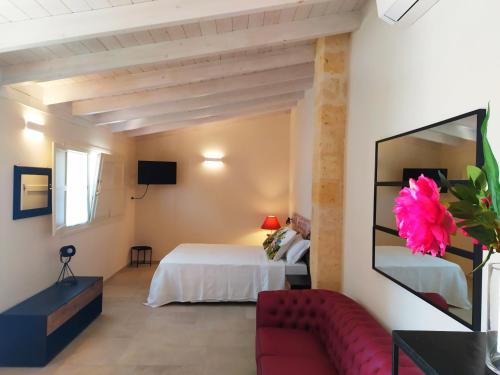 a room with a bed, a table, and a painting on the wall at Masseria Baroni Nuovi in Brindisi