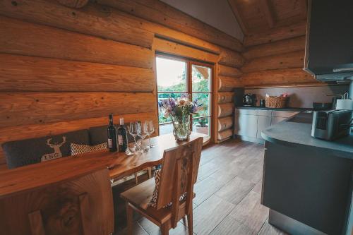 a kitchen with a table and chairs in a log cabin at Landhaus Auszeit in Grafengehaig