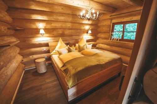 a bedroom with a bed in a log cabin at Landhaus Auszeit in Grafengehaig