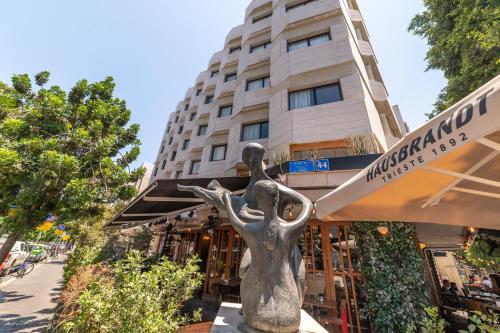 a statue of a woman in front of a building at 130 Rock Apartments in Tel Aviv