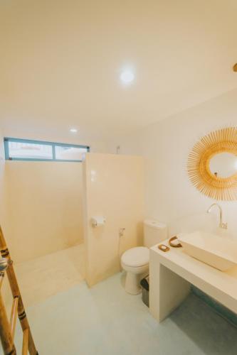 a bathroom with a toilet and a sink and a mirror at Birru Inn in Kuta Lombok