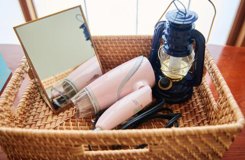 a wicker basket with a laptop and pens and a lamp at Hostel Coliberty in Tokushima