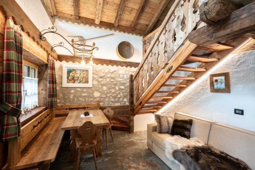 a room with a table and a couch and stairs at Camping Catinaccio Rosengarten in Pozza di Fassa