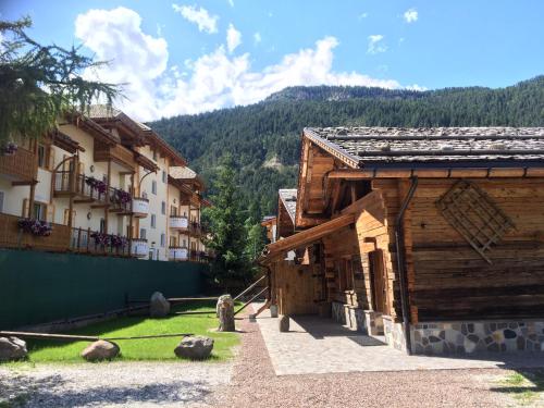 a wooden building with a mountain in the background at Camping Catinaccio Rosengarten in Pozza di Fassa