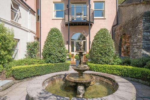 a fountain in a courtyard in front of a building at Perryville House in Kinsale