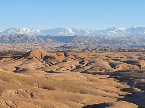 a desert with a mountain range in the background at Nkhila Lodge in Marrakech
