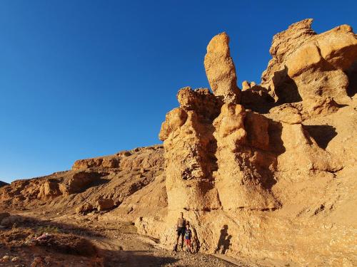 a man with a bike standing next to a rock formation at Nkhila Lodge in Marrakech