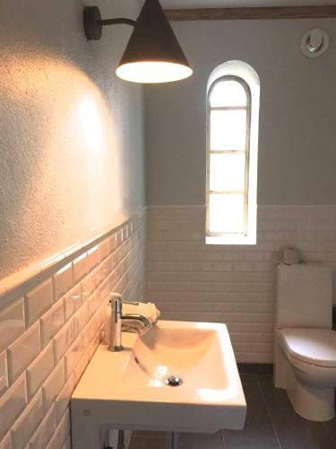 a bathroom with a sink and a toilet at Gladeholm - Kivik - artist studio in Kivik