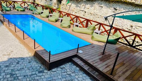 a large swimming pool with green pillows next to a building at ZimaSnow Ski & Spa Club in Bukovel