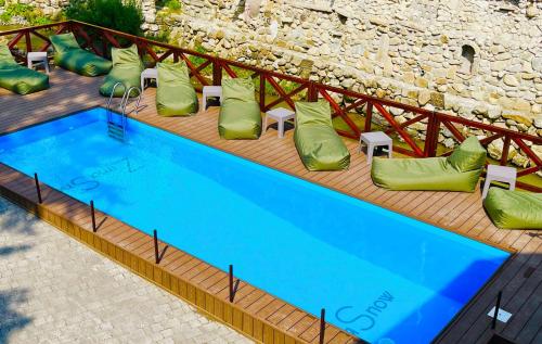 a large blue swimming pool with green pillows and chairs at ZimaSnow Ski & Spa Club in Bukovel