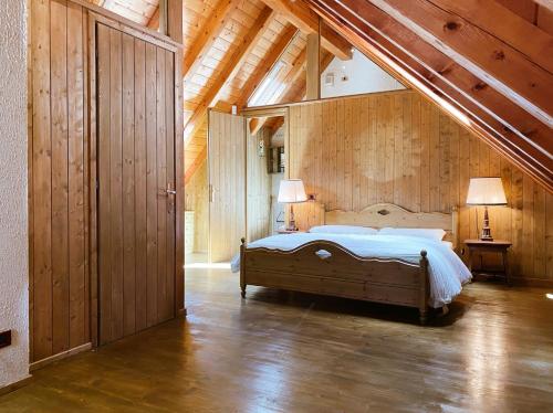 a bedroom with a bed in a room with wooden walls at Betulla House - AffittiPontediLegno in Ponte di Legno