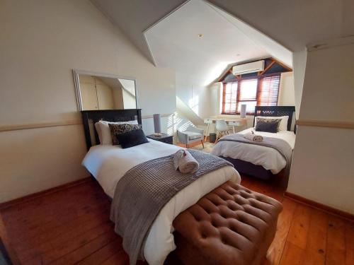 1 Schlafzimmer mit 2 Betten und einem Spiegel in der Unterkunft The Oak Potch Guesthouse in Potchefstroom