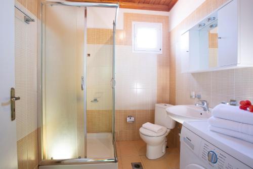 ein Bad mit einer Dusche, einem WC und einem Waschbecken in der Unterkunft Konstantino's House in Áyios Ilías