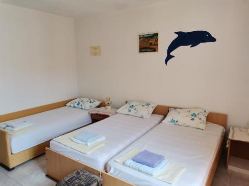 2 camas en una habitación con un delfín en la pared en Apartments Radonic, en Hvar