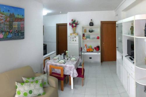 ein Wohnzimmer mit einem Esstisch und einer Küche in der Unterkunft Casa Bahia in Marina di Davoli