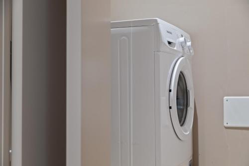 a white refrigerator with a washing machine in a room at JOIVY Treviso Vittoria in Treviso