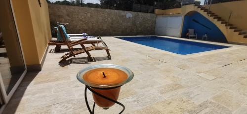 uma vela sobre uma mesa ao lado de uma piscina em Can Salgas em Montrás