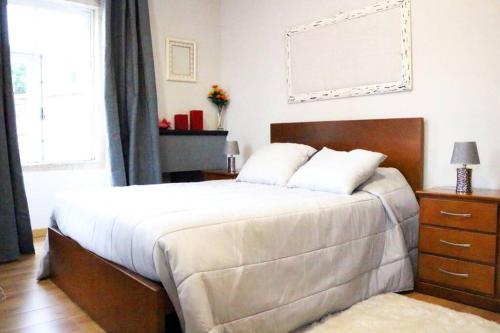 a bedroom with a bed and a dresser and a window at Casa do Adro- Douro in Peso da Régua