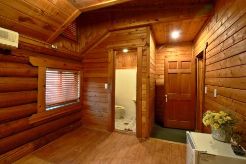 un bagno in legno con servizi igienici e porta di Muju Log House Pension a Muju