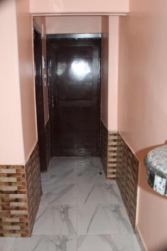 a hallway with a black door in a room at Tiba Hotel in Aswan