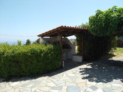 a wooden pergola sitting next to some bushes at Ellina's Home - Euboea island Greece in Oxílithos