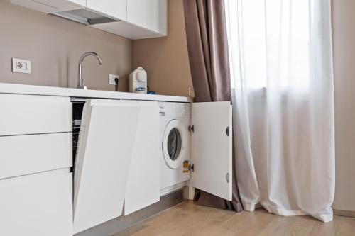 a kitchen with a washing machine and a sink at JOIVY Treviso Vittoria in Treviso