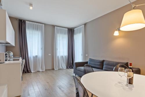 a living room with a table and a couch at JOIVY Treviso Vittoria in Treviso