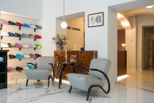 a waiting room with chairs and a table and shelves at Hotel & Gallery Kopacka in Svitavy