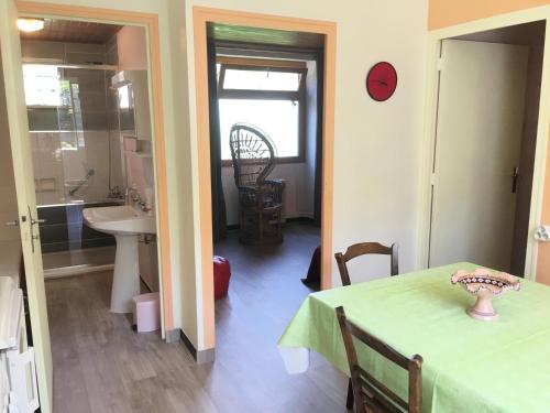 Habitación con mesa y baño con lavabo. en RANDO BAIN CUEILLETTE Profitez des CÉVENNES, en Chamborigaud