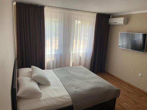 um quarto com uma cama grande e uma janela em Апартаменты возле Днепра em Cherkasy