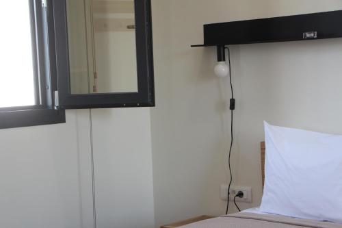 a mirror above a bed with a white pillow at Chill and Thrill Apartments in Mastichari