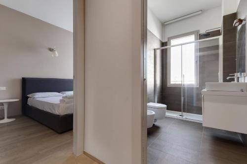 a bathroom with a bed and a toilet and a sink at JOIVY Treviso Vittoria in Treviso