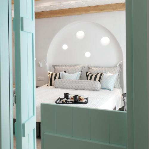 a bedroom with a bed with a tray on it at Majo Suites Hotel in Agia Anna Naxos
